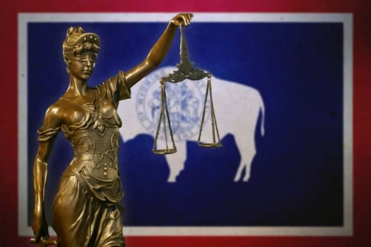Lady Justice in front of the Wyoming flag.