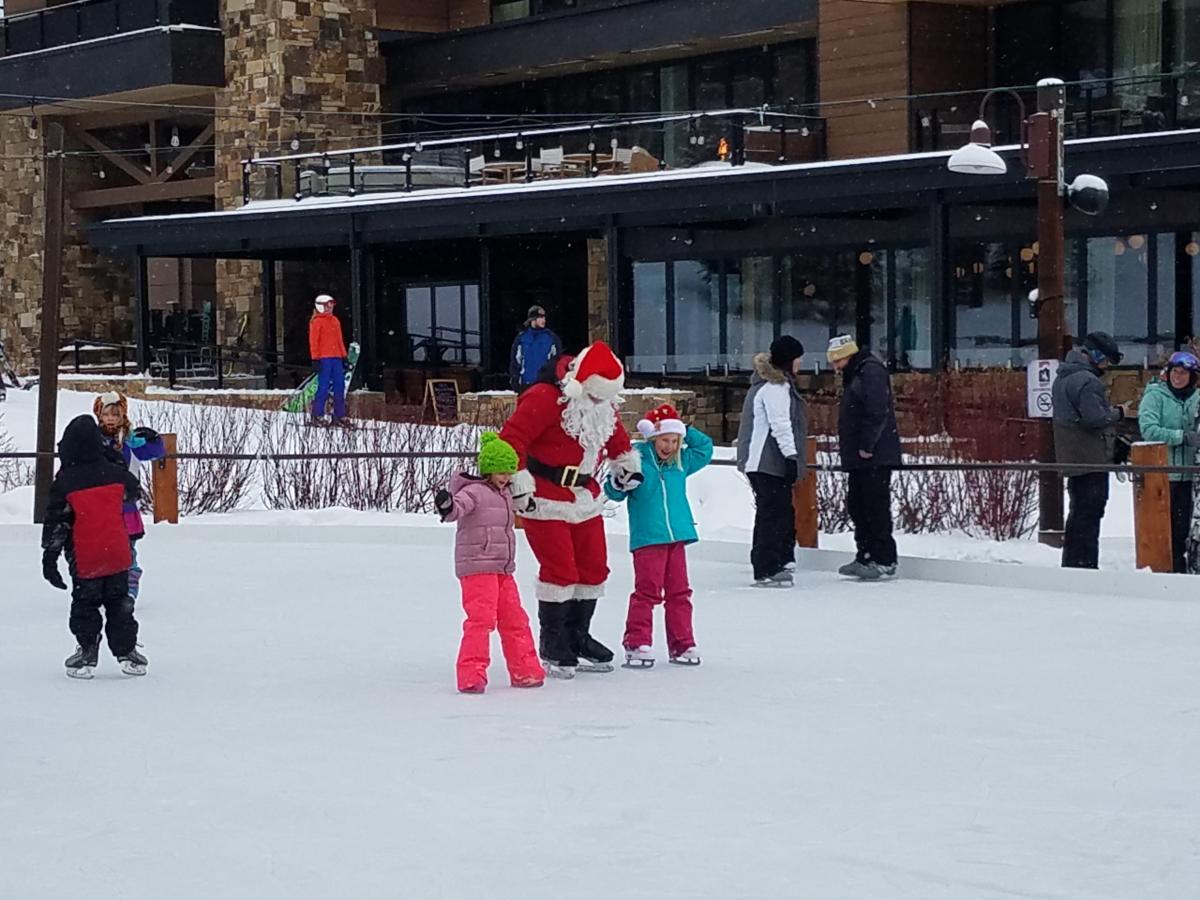 Santa skates with two children on the Village Rink on the Commons in Teton Village, WY.