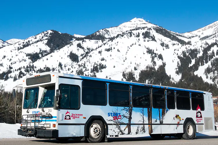 Jackson's START Bus in Teton Village, WY, with a view of the Grand Teton Range.