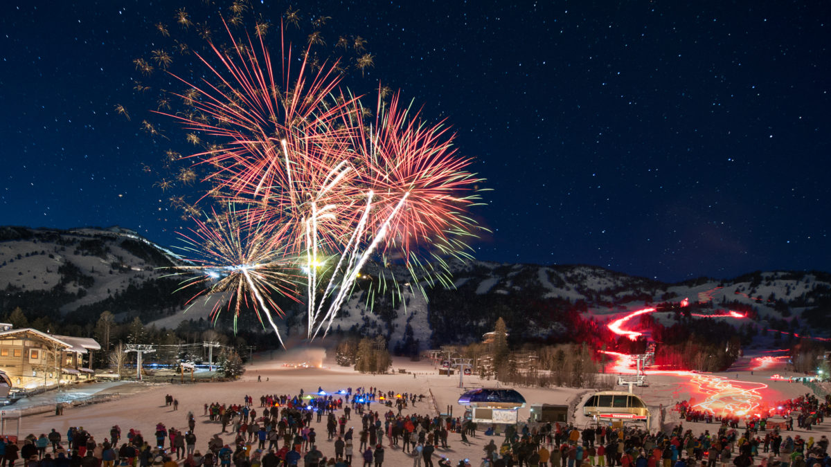 Fireworks explode with ski slopes in the background in Teton Village, WY.
